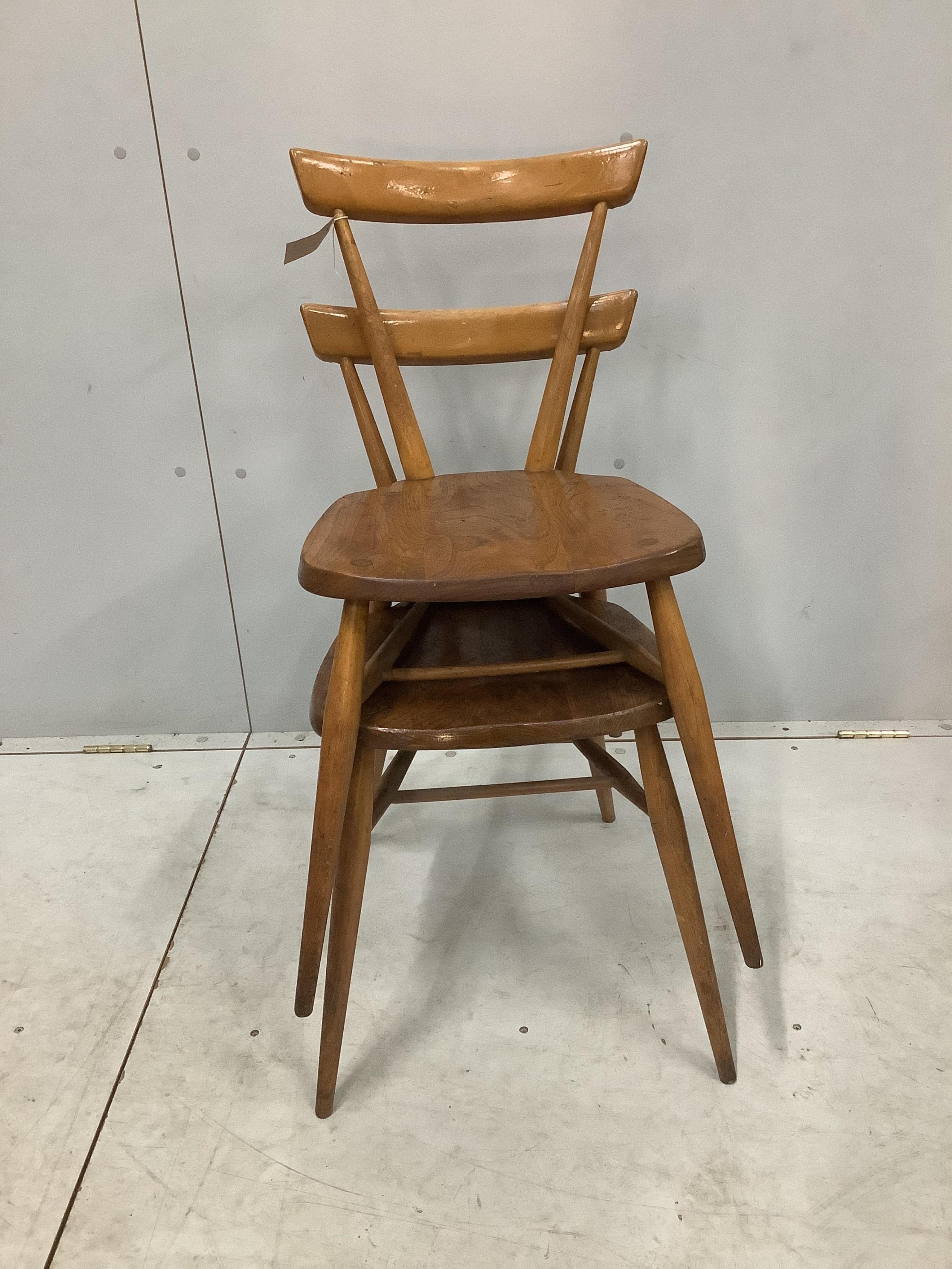 A pair of mid century Ercol elm and beech stacking chairs, width 39cm, depth 35cm, height 76cm. Condition - fair